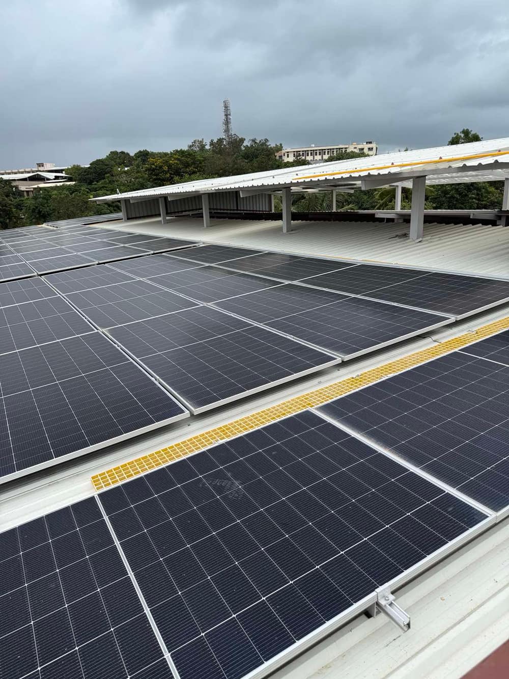 Rooftop solar array on a school building, panels laid across a metal-sheet roof